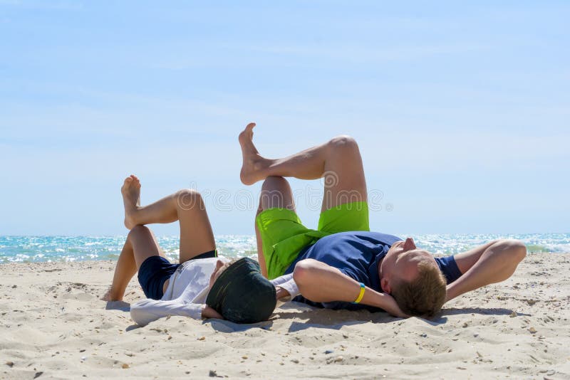 Wochenende am Strand Vati und Sohn liegt auf dem Strand Vati und Sohn, die auf dem Strand sich entspannen lizenzfreie stockbilder Wochenende am Strand Vati und Sohn liegt auf dem Strand Vati und Sohn, die auf dem Strand sich entspannen lizenzfreie stockbilder