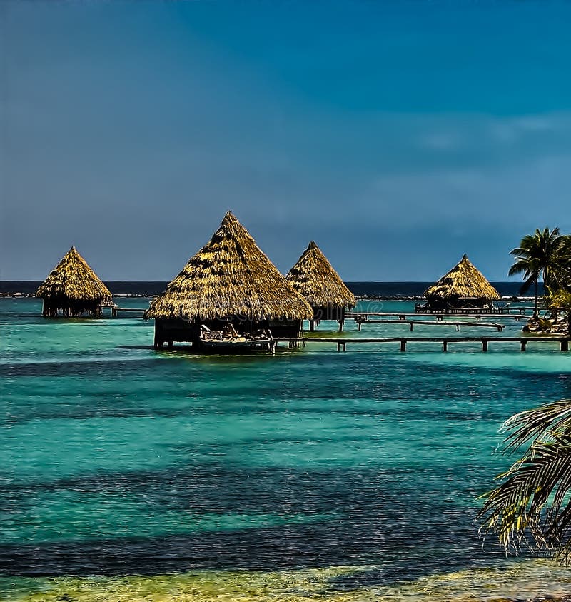 Some of the thatched roofed bungalows, over blue-green waters in Glover`s Atoll, Belize. Some of the thatched roofed bungalows, over blue-green waters in Glover`s Atoll, Belize