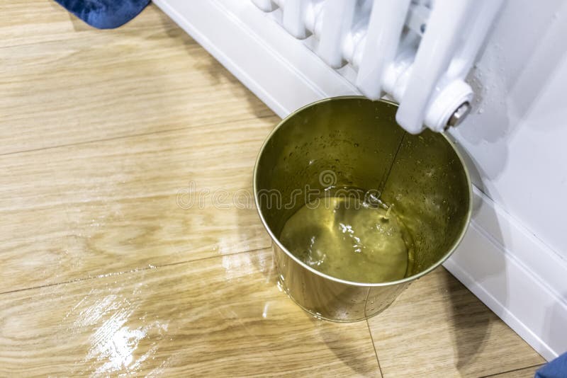 Woda opuszcza dolewanie na podłodze od białego grzejnika fotografia royalty free Woda opuszcza dolewanie na podłodze od białego grzejnika fotografia royalty free