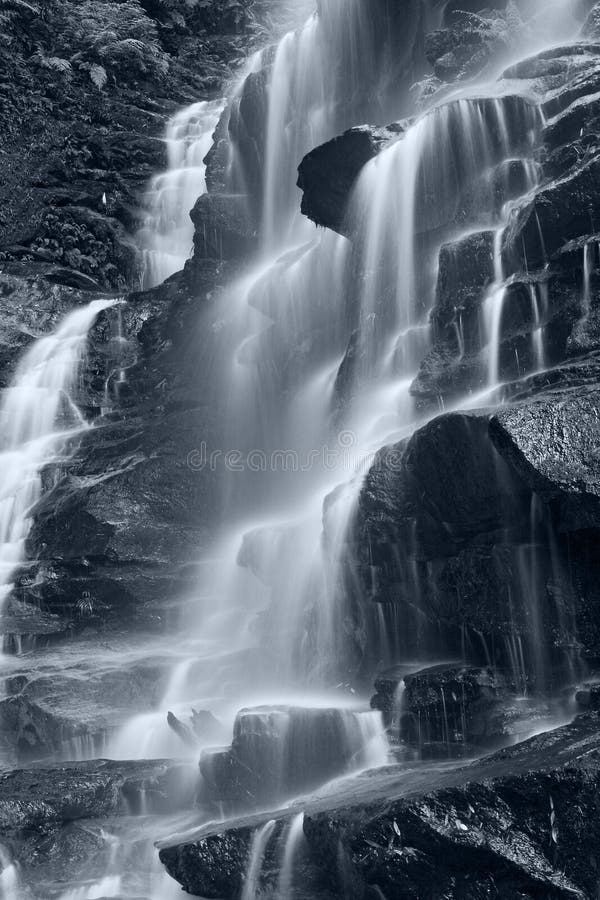 Beautiful waterfall in vertical composition. Wenworth Falls, Blue Mountains - National Park, NSW, Australia. Blue toning. Beautiful waterfall in vertical composition. Wenworth Falls, Blue Mountains - National Park, NSW, Australia. Blue toning.