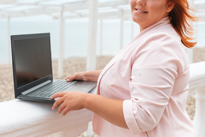 Wolny. portret kaukaskiej szczęśliwej kobiety trzymającej laptop. modele o rozmiarze plus. na zewnątrz. pojęcie pracy na odległość obrazy stock