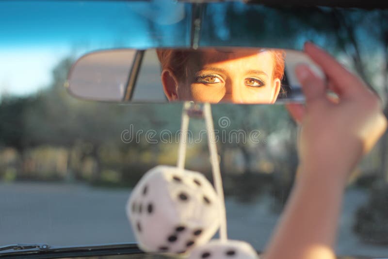 Woman Adjusting Rear View Mirror