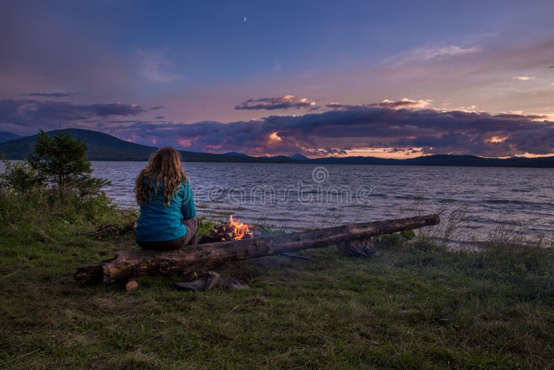 A woman admiring the sunset over the lake