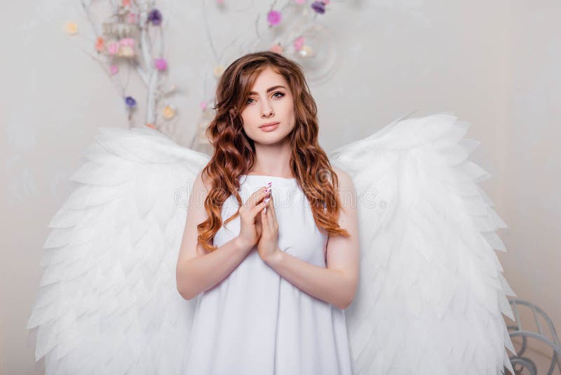 Angel in a White Dress with Wings Behind His Back and a Halo Over