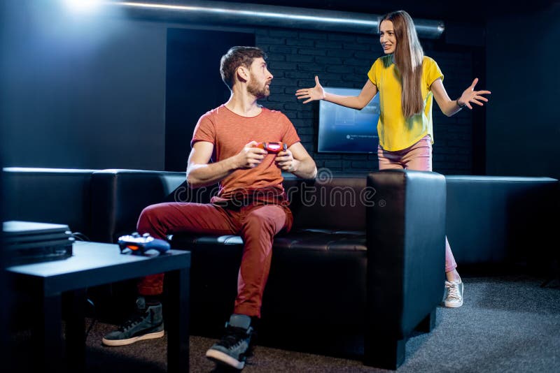 Man beating woman at video games with controller on console over blue background. Boyfriend celebrating win and girlfriend feeling disappointed about losing online gameplay in studio Stock Photo - Alamy
