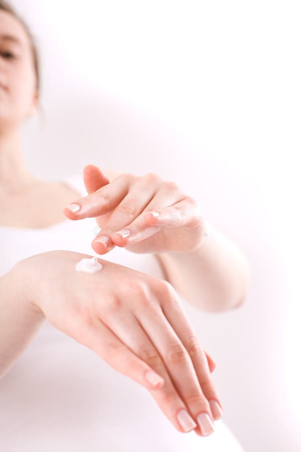 Woman applying cream on her hands stock images