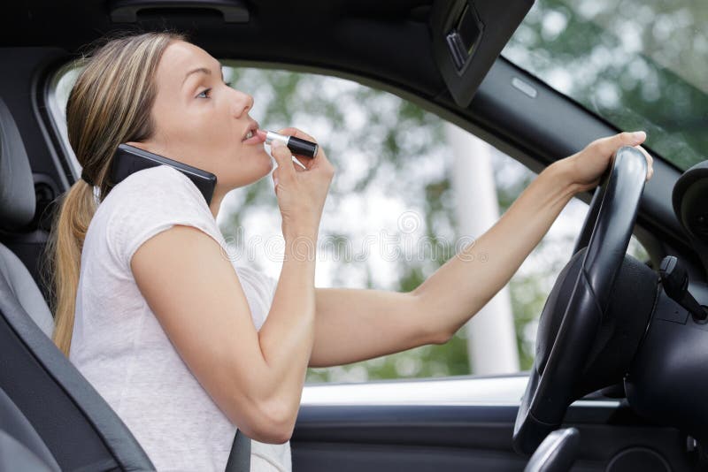 Woman Applying Makeup while Driving Car Stock Photo - of automobile, lipstick: 148280330