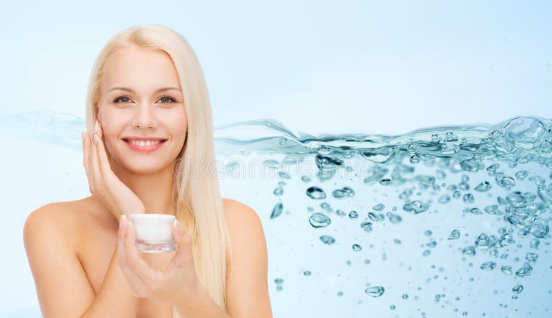 Woman applying moisturizing cream to her face skin stock photography Woman applying moisturizing cream to her face skin stock photography