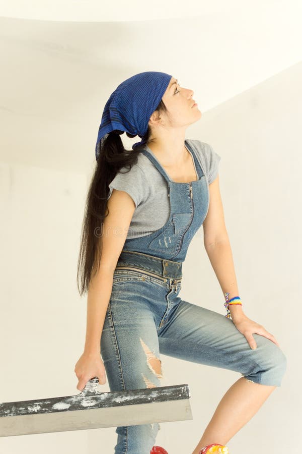 Woman applying wallpaper looking at her work stock images