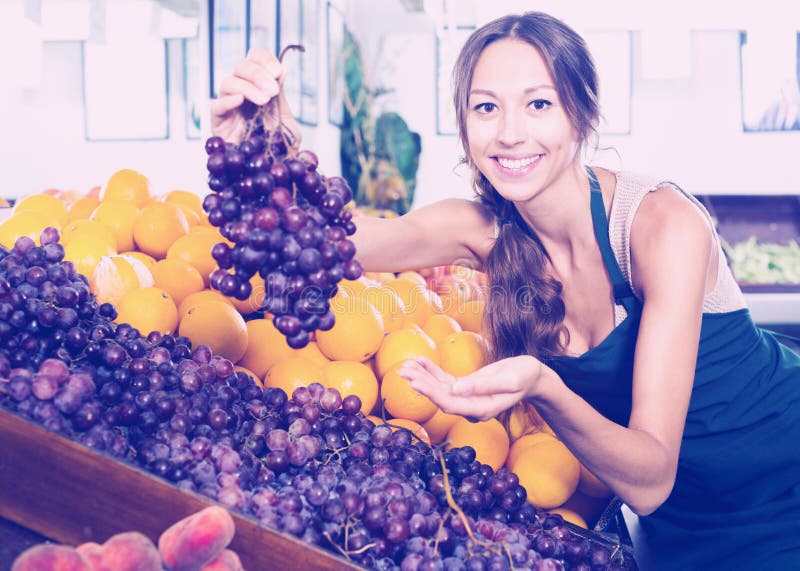 Woman in apron selling ripe grapes in shop royalty free stock image Woman in apron selling ripe grapes in shop royalty free stock image
