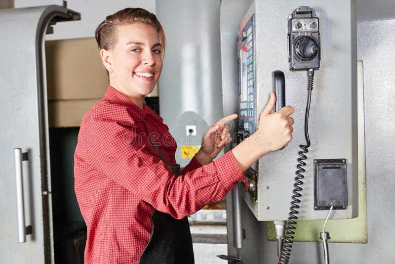 Woman as machinist works with CNC machine