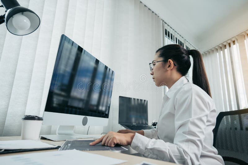 Woman asian software developers are analyzing together about the code written into the program on the computer in office room stock photo