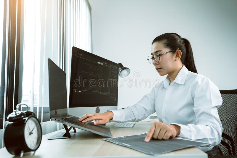 Woman asian software developers are analyzing together about the code written into the program on the computer in office room stock photos
