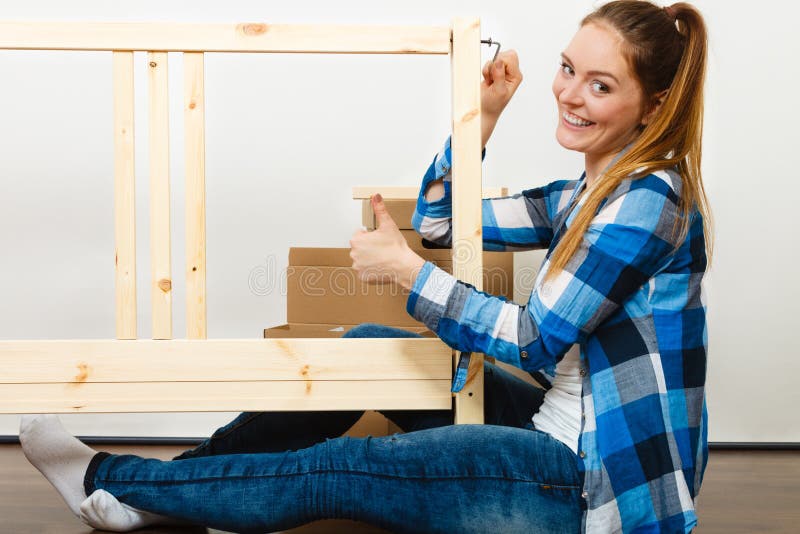 Woman assembling wooden furniture. DIY.