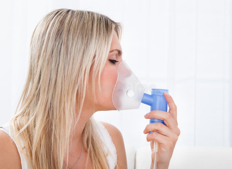 Woman with asthma inhaler royalty free stock image
