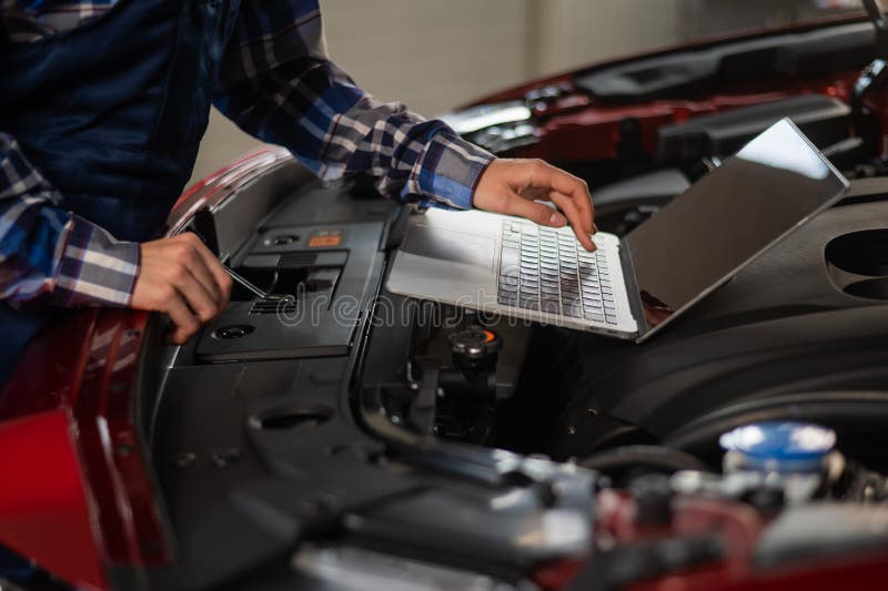 Woman Auto Mechanic Doing Engine Diagnostics Using Laptop. Stock Image