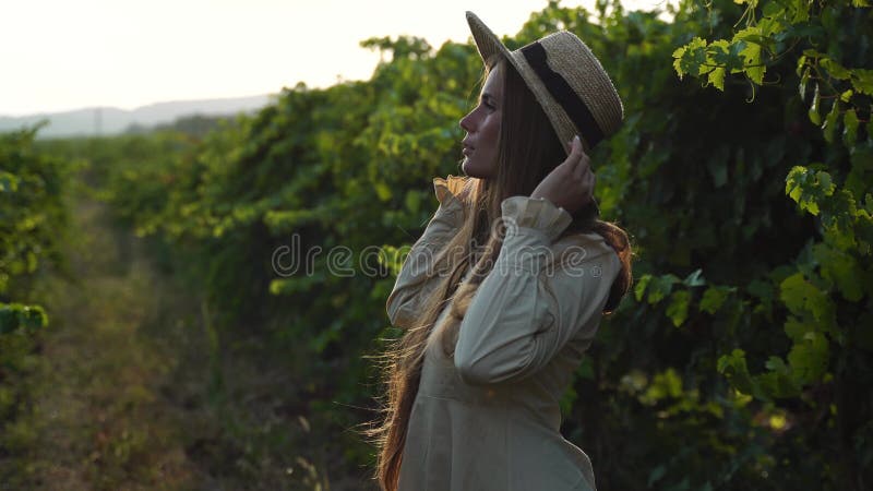 Woman at autumn winery. Portrait of happy woman holding glass of wine and enjoying in vineyard. Elegant young lady in