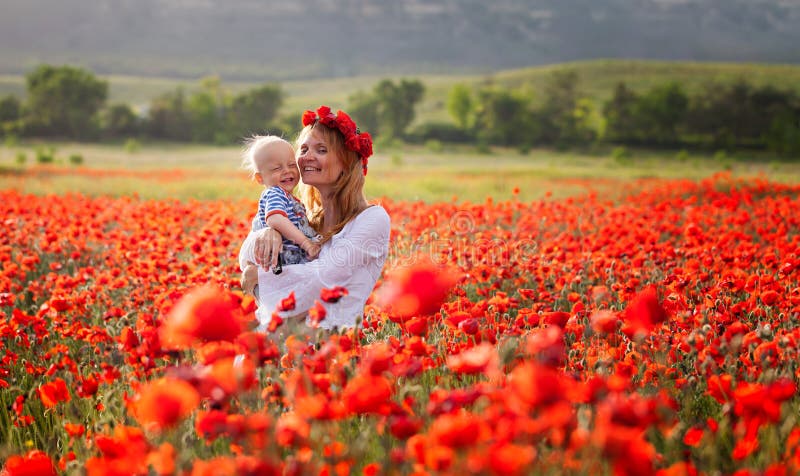 Woman with baby in a field of red poppies