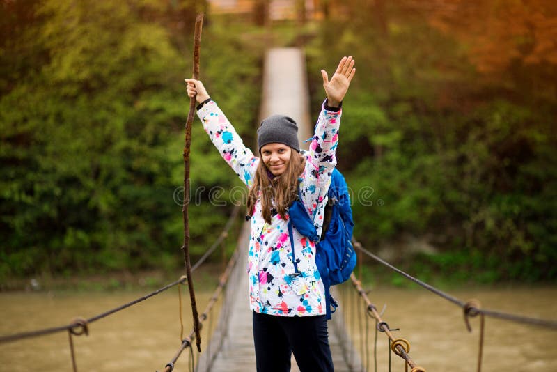 Woman with backpack and hands up hiking Lifestyle adventure concept forest and cross river in forest active vacations royalty free stock image Woman with backpack and hands up hiking Lifestyle adventure concept forest and cross river in forest active vacations royalty free stock image