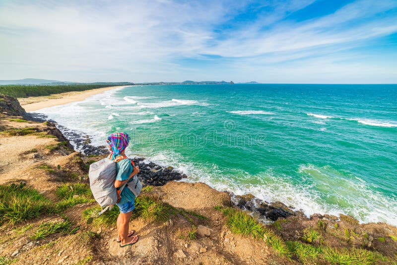 Woman with backpack looking at tropical coast from cliff above. Vietnam travel destination, Phu Yen province between Da Nang and royalty free stock photography Woman with backpack looking at tropical coast from cliff above. Vietnam travel destination, Phu Yen province between Da Nang and royalty free stock photography
