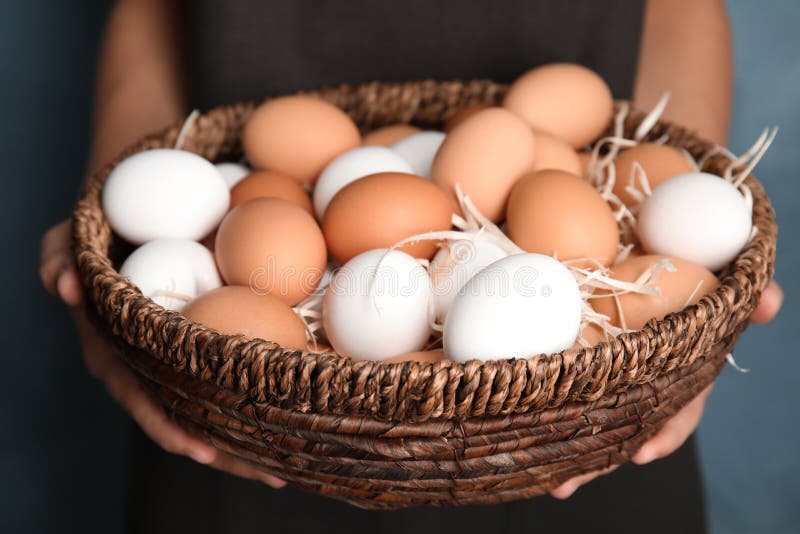 Woman with basket full of raw chicken eggs