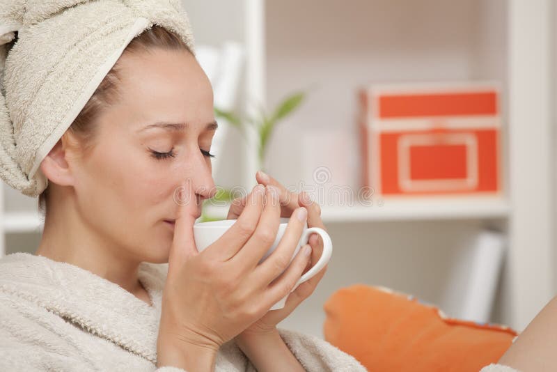 Woman in bathrobe drinking tea