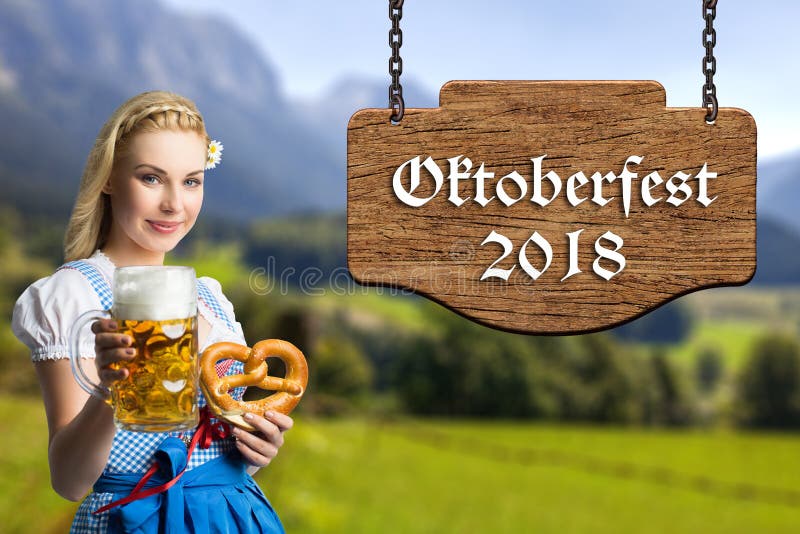 Woman in a bavarian dirndl with beer and pretzel and the text `Oktoberfest 2018` royalty free stock photo Woman in a bavarian dirndl with beer and pretzel and the text `Oktoberfest 2018` royalty free stock photo