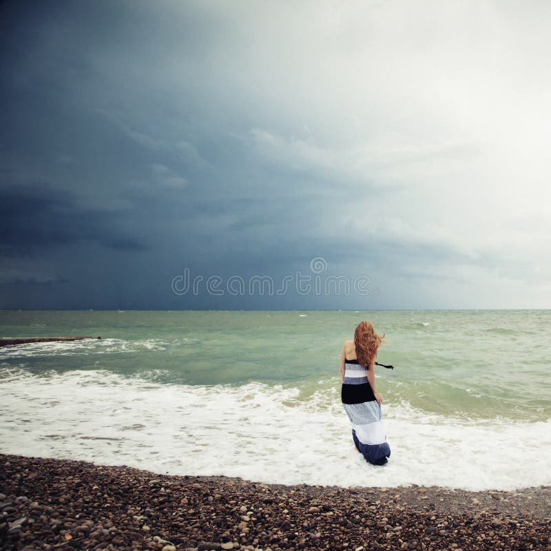 The woman on the beach during a storm stock photos The woman on the beach during a storm stock photos