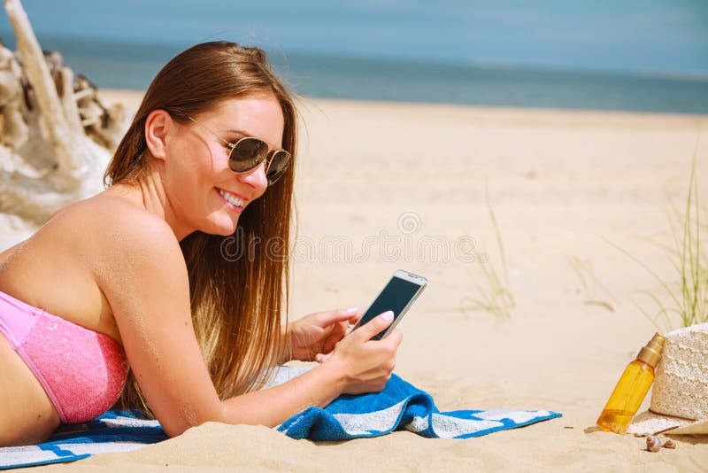 Woman on beach texting on smartphone. stock images Woman on beach texting on smartphone. stock images