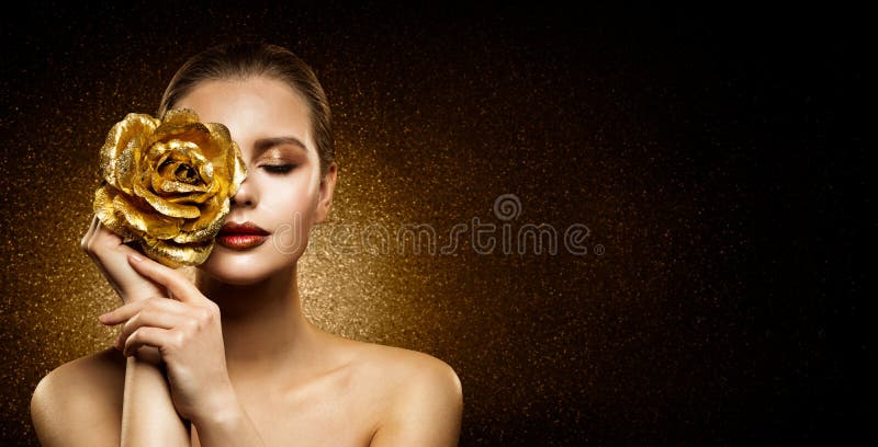 Woman Beauty Perfect glowing Skin Makeup. Fashion Model holding Golden Rose Flower over Face and covering Closed Eye. Artistic