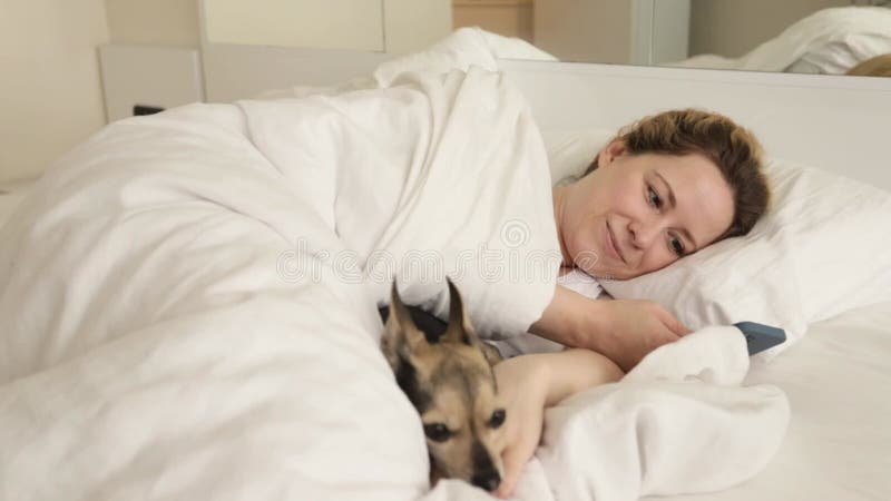 A woman in bed with a phone in the morning, Online chats, pet shop, online banking