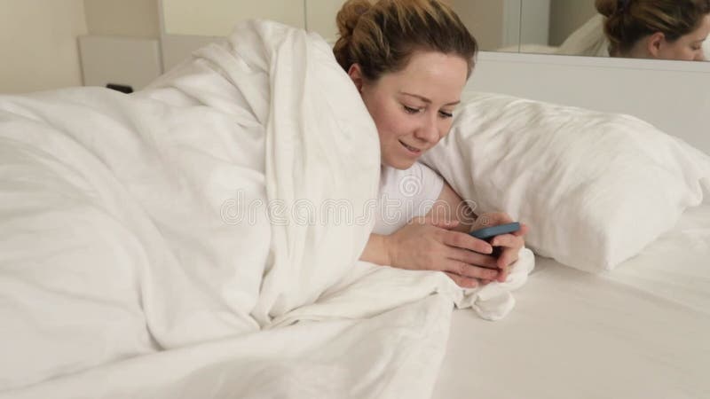 A woman in bed with smartphone, Online chats, social networks