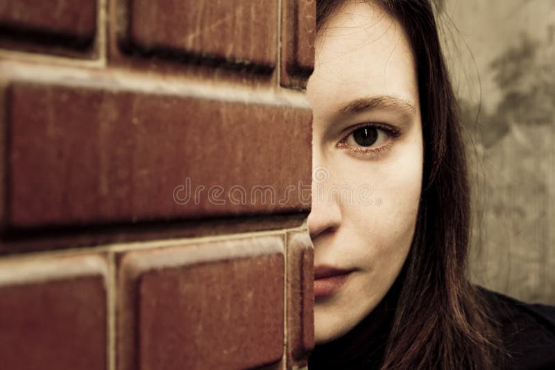 Woman behind brickwall