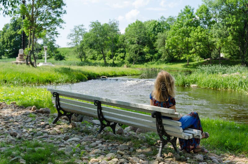 Woman on bench admire fast flow river water stream