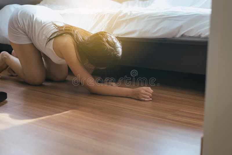 Woman bent and searching something under bed lost thing