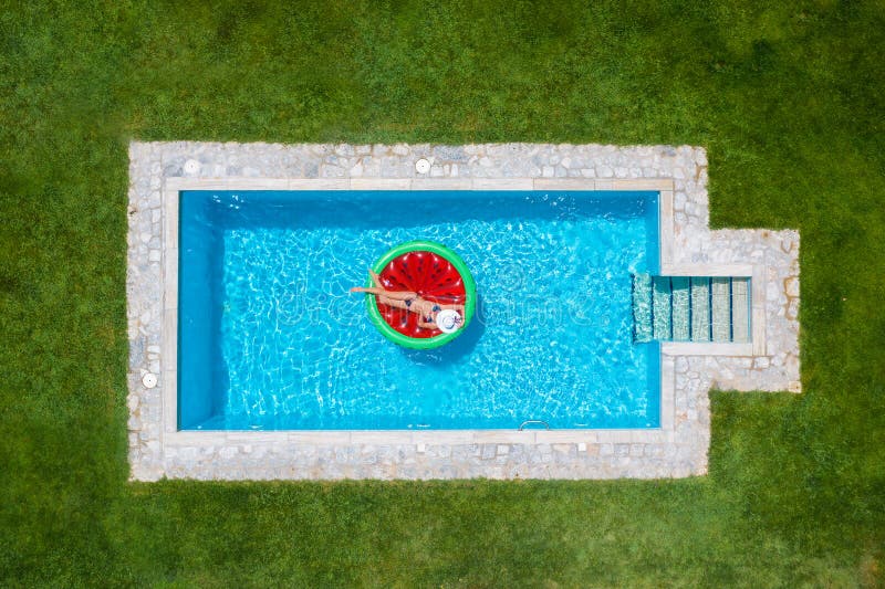 A woman in bikini floats on a watermelon shaped float in a pool royalty free stock photo A woman in bikini floats on a watermelon shaped float in a pool royalty free stock photo