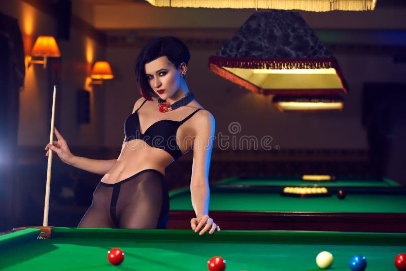 Woman at billiards club playing snooker. 