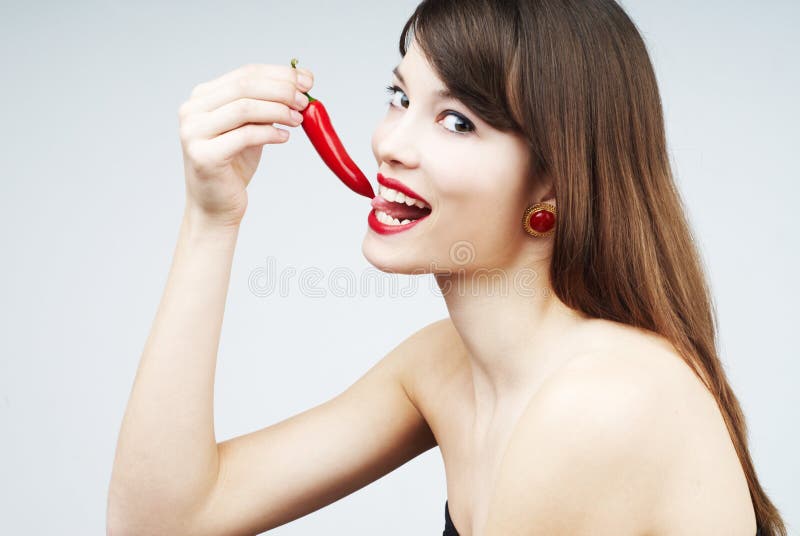 Woman biting a chili pepper