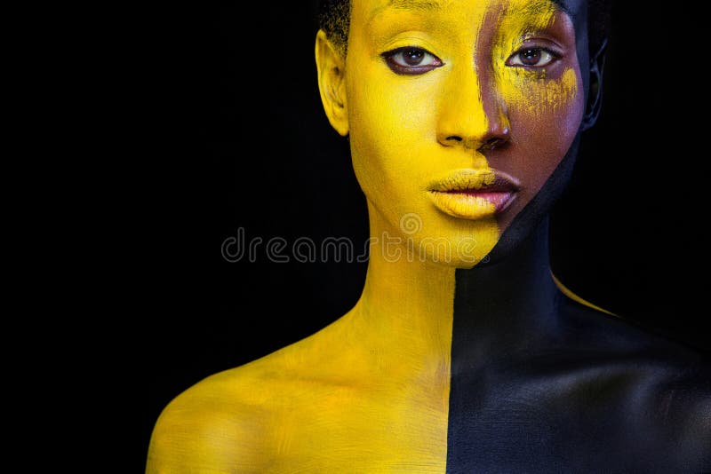 Yellow and black body paint. Woman with face art. Young girl with