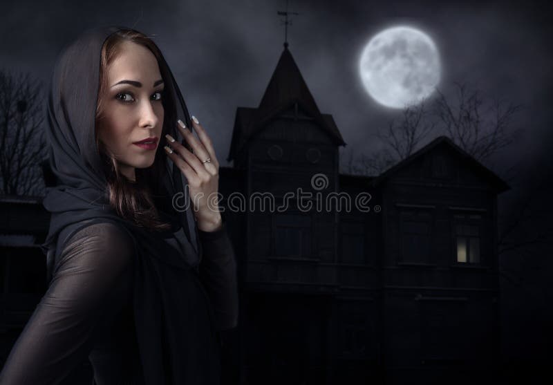 Woman in black in front of old house on a moonlit night
