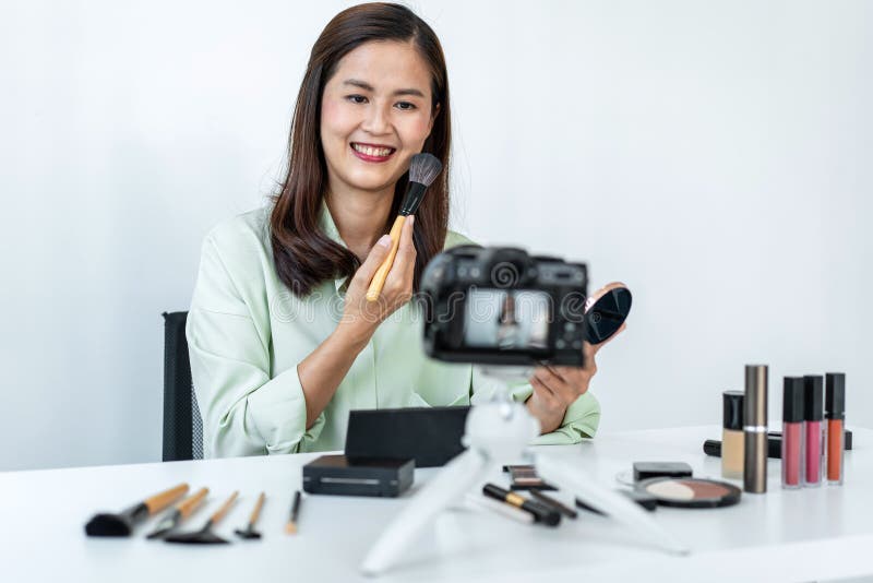 Woman blogger is showing present make up tutorial beauty cosmetic review product and broadcast live streaming video to social royalty free stock photography