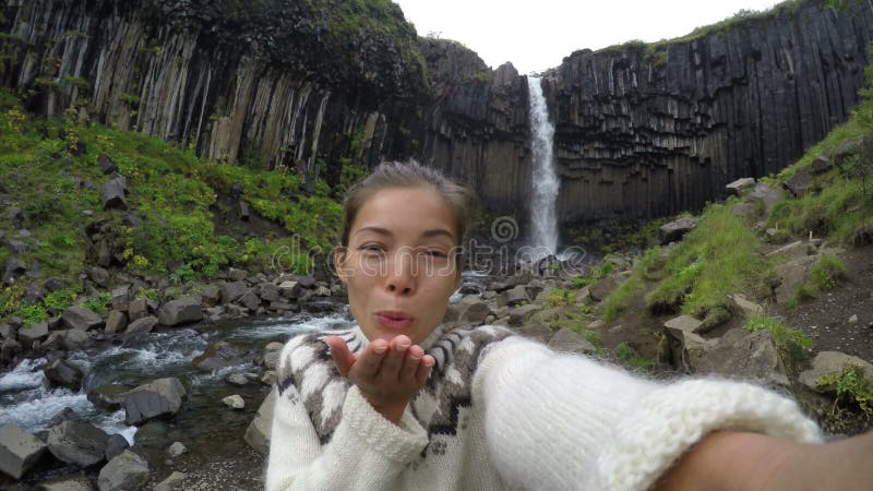 Woman Blowing Kiss Against Svartifoss Waterfall