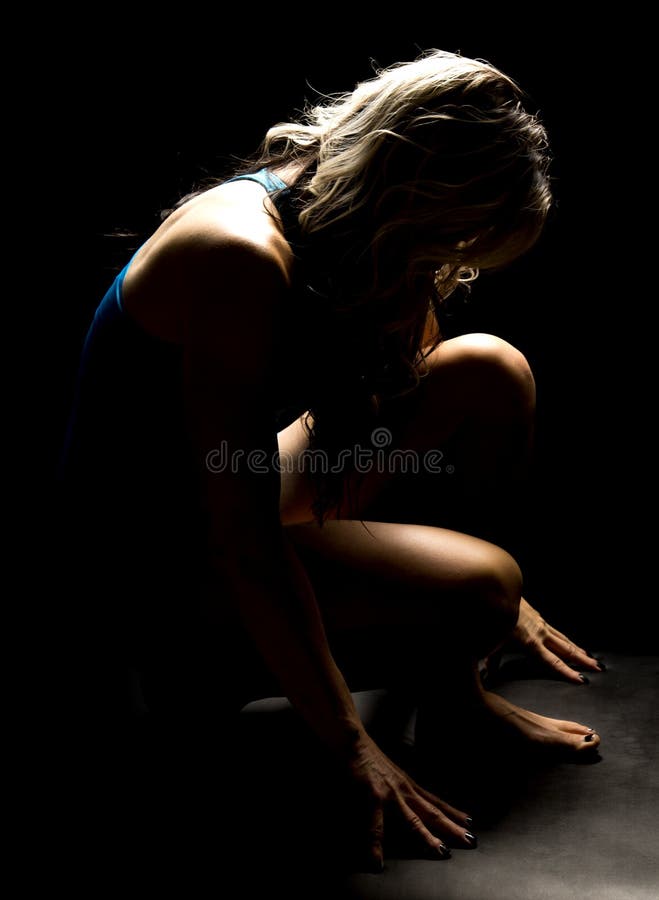 Woman in blue shorts highlighted from back hunched down royalty free stock photos Woman in blue shorts highlighted from back hunched down royalty free stock photos