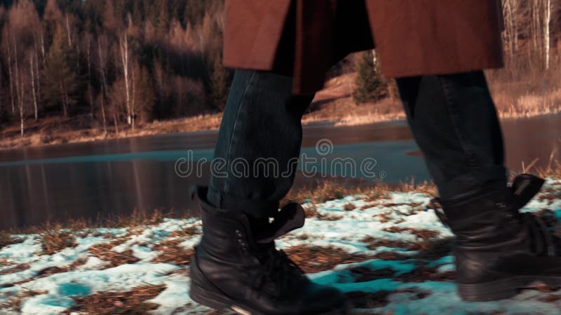 Woman in boots walks in the snow