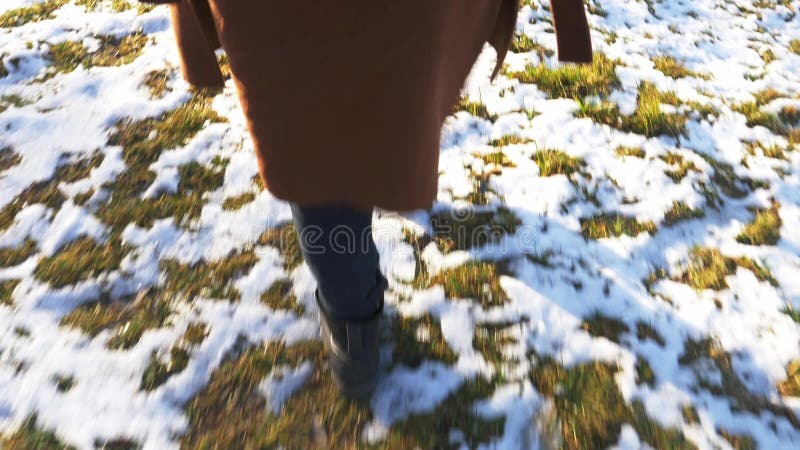 Woman in boots walks in the snow