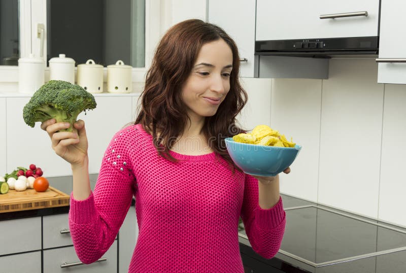 Woman with a bowl of potato chips and broccoli stock photography Woman with a bowl of potato chips and broccoli stock photography