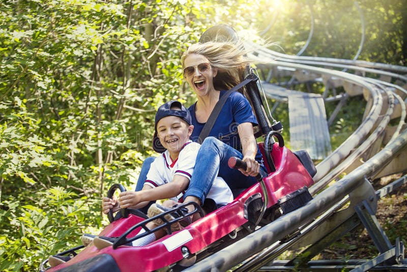 Woman and boy enjoying a summer fun roller coaster ride royalty free stock photography Woman and boy enjoying a summer fun roller coaster ride royalty free stock photography