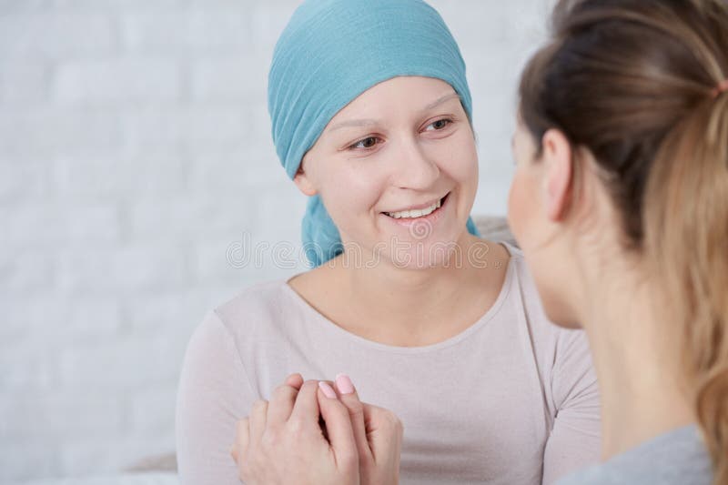 Woman with brain tumor wearing headscarf, having family support