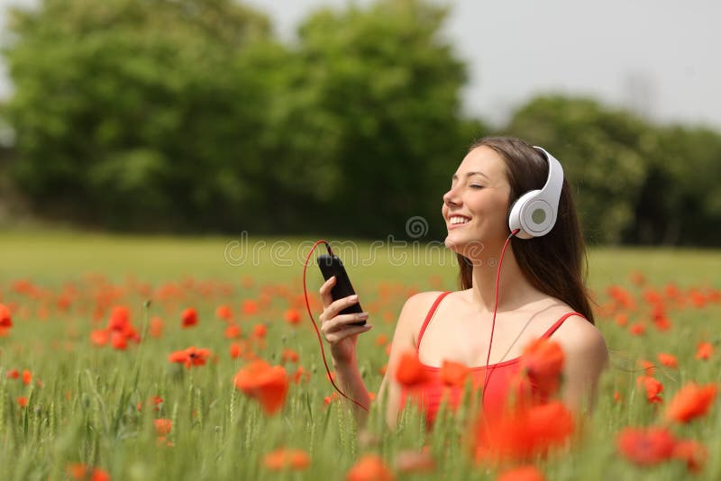 Woman breathing and listening music in a field stock photography Woman breathing and listening music in a field stock photography