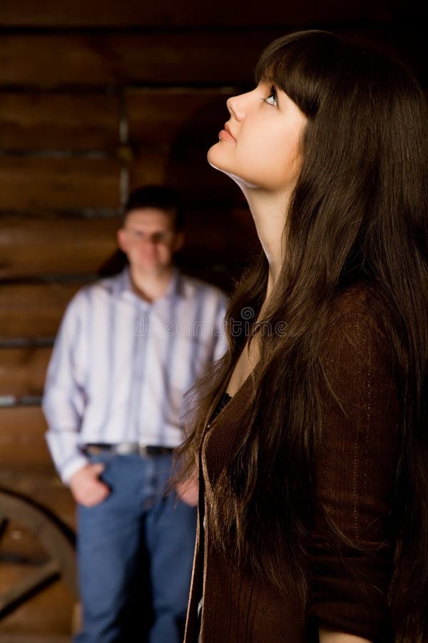 Woman brunette and young man in wooden log hut